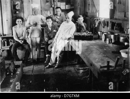 Cette image montre des membres de la Compagnie 1309 du Civilian conservation corps (CCC) jouissant de beignets pendant une pause dans leur travail. Le CCC était un programme d'aide au travail public pendant la Grande dépression, fournissant des emplois à de jeunes hommes dans des projets de conservation et d'infrastructure. Banque D'Images