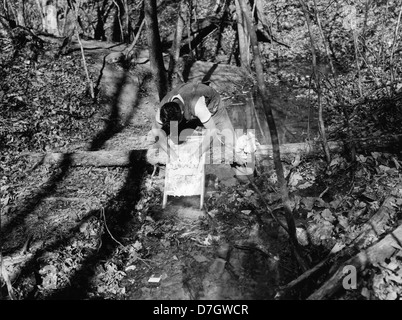 Une photographie historique de « Wash Day at Camp Roosevelt » dans la forêt nationale George Washington, Virginie, montre des membres du Civilian conservation corps effectuant des tâches de blanchisserie. L'image donne un aperçu de la vie quotidienne au camp pendant la Grande dépression. Banque D'Images