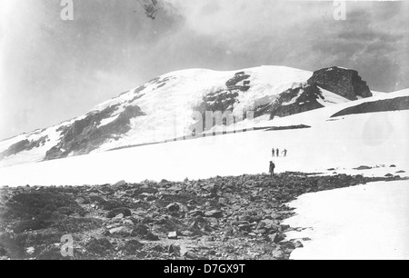 Cette photographie de la collection Gerald W. Williams capture des membres du club d'alpinisme Mazamas près du sommet du mont Rainier. L'image souligne la détermination des grimpeurs et le paysage majestueux du Nord-Ouest Pacifique. Banque D'Images