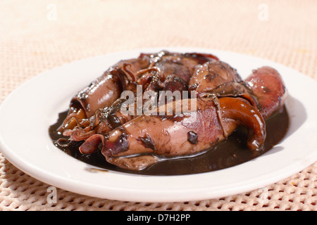 Assiette de petits calmars sautés compote dans la sauce de soja et le vinaigre. Banque D'Images