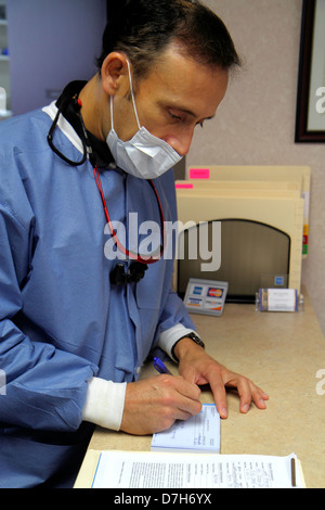 Miami Beach Florida,cabinet de dentiste,dentaire,médecin médecins,masque facial,écriture,perscription,hispanique latin Latino immigrants ethniques minorités,homme Banque D'Images