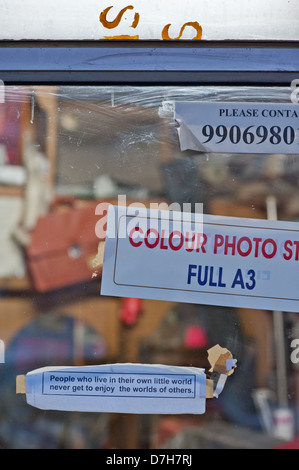 Messages imprimés et des signes dans la fenêtre d'un atelier d'impression. Leh, Inde. Banque D'Images