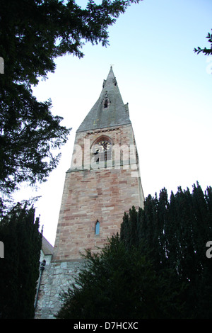 Photo de l'église St Pierre, couleurs et spire, Ruthin Denbighshire, Wales, avec yew arbres en premier plan Banque D'Images