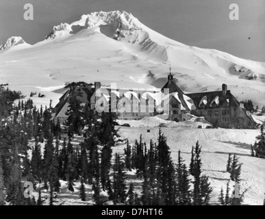 Cette photographie vintage datant d'environ 1935 capture Timberline Lodge et Mount Hood dans l'Oregon, mettant en valeur le pavillon de montagne emblématique avec pour toile de fond le majestueux Mount Hood, populaire pour sa station de ski et ses vues imprenables. Banque D'Images