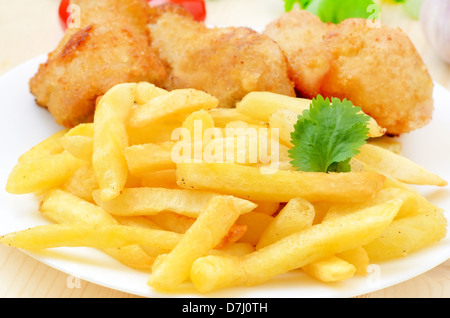 Frites avec du poulet frit sur une plaque blanche Banque D'Images