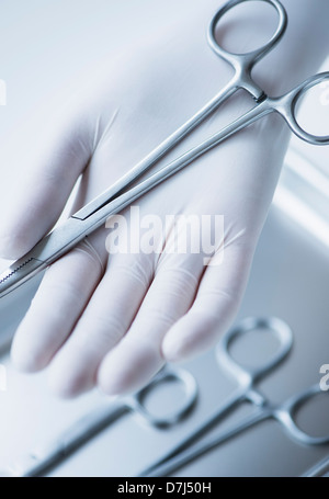 Close up of hand holding dans les gants chirurgicaux pinces dentaires, studio shot Banque D'Images