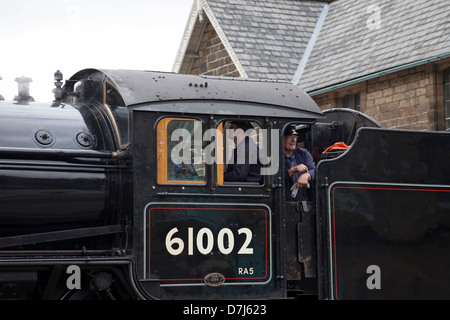 Membre de l'équipage à la recherche hors de la Locomotive à vapeur 61002 Impala lorsqu'il quitte la station de Grosmont NYMR Yorkshire Angleterre UK Banque D'Images