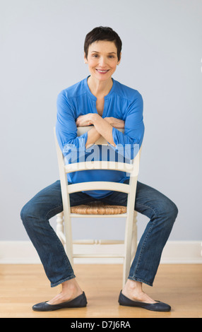 Portrait of mature woman sitting on chair Banque D'Images