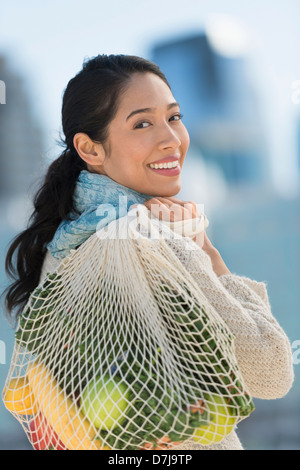 Portrait of smiling young woman with grocery shopping bag Banque D'Images