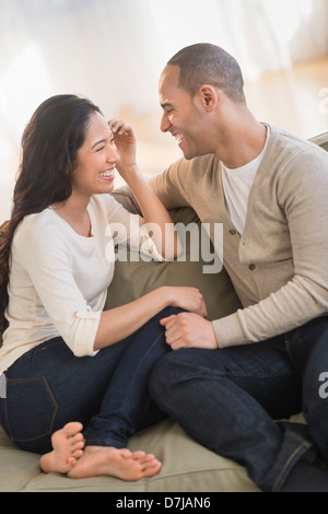 Portrait of young couple sitting on couch Banque D'Images