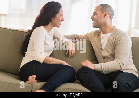 Portrait of young couple sitting on couch Banque D'Images