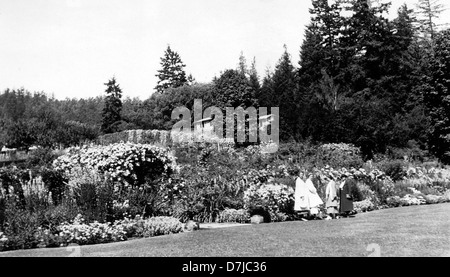 Cette photographie de 1935 illustre la beauté des jardins Butchart près de Victoria, en Colombie-Britannique. L'image met en valeur le paysage floral luxuriant, les allées de jardin méticuleusement conçues et les couleurs vibrantes, reflétant le statut du jardin comme une attraction touristique populaire et une vitrine de l'excellence horticole. Banque D'Images