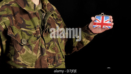Soldat tenant une Union Jack bourse d'argent. C'est soldat portant uniforme de camouflage militaire britannique. Banque D'Images