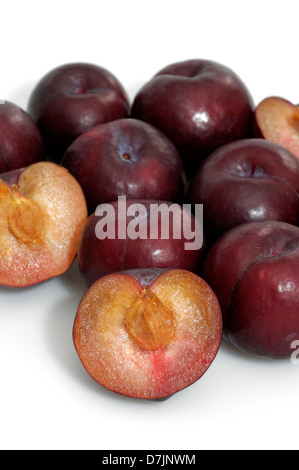 Organic prunes rouges entières ou coupées en deux Banque D'Images