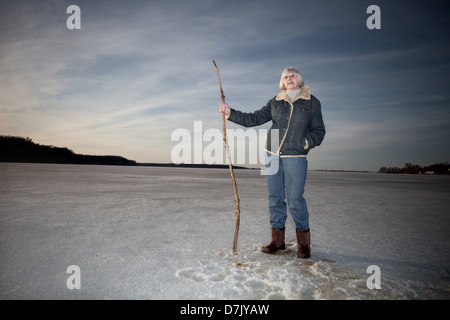 Portrait de l'environnement de la femme dans ses 70 Comité permanent sur le lac holding stick canne Banque D'Images