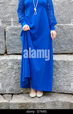 Une femme dans une robe bleue est debout sur les marches de pierre Banque D'Images