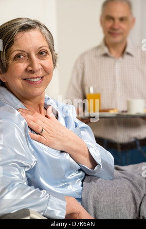 Mari à la retraite ce qui porte à son petit-déjeuner au lit femme malade Banque D'Images