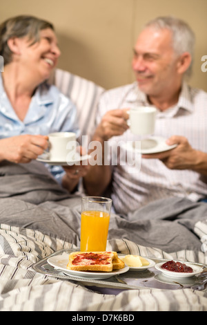 Mature couple bénéficiant d'un petit-déjeuner romantique en chambre d'hôtel Banque D'Images
