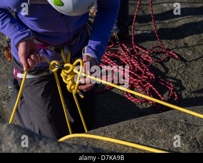 Des alpinistes de la préparation avant de descendre Stanage Edge falaise dans le Derbyshire Peak District UK Banque D'Images