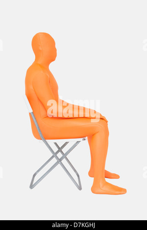 Homme mûr en orange zentai sitting on chair Banque D'Images