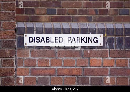 Parking handicapés signe sur un mur de briques Banque D'Images