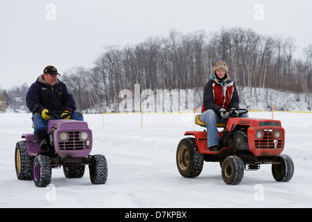 Un homme et une femme vieille route tondeuses pendant un défilé pré-événement avant la première assemblée annuelle de la glace sur les courses de tondeuse à gazon Knife Lake. Banque D'Images