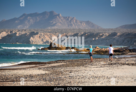 Cabo Pulmo, Mexique, Frère et Sœur marche sur plage déserte avec arrière-plan la montagne. (MR) Banque D'Images