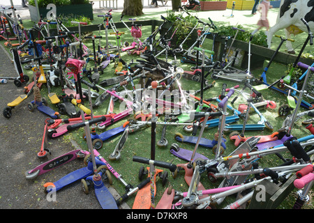 Les enfants dans un parc de scooters scooter dans une école primaire de Londres Banque D'Images