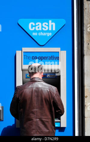 Un homme à l'aide d'un distributeur de billets à la Co-operative Bank dans le centre de Londres, au Royaume-Uni. Banque D'Images