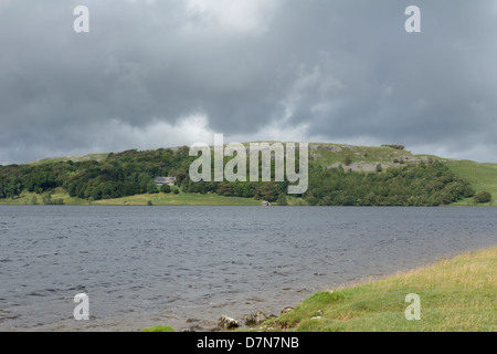 Malham Tarn dans Yorkshire du nord dominé par les rochers de calcaire avec l'Malham Tarn entre le centre du champ. Banque D'Images