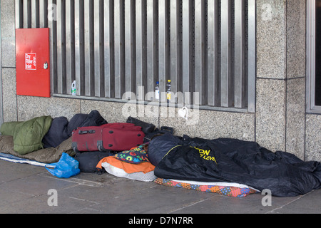 Les sans-abri dormant dans les rues de Londres Angleterre enveloppé contre le froid dans des sacs de couchage Banque D'Images