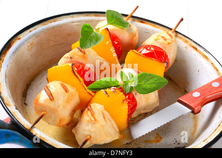 Morceaux de poulet grillé avec tomates cerises et poivron jaune en brochettes Banque D'Images