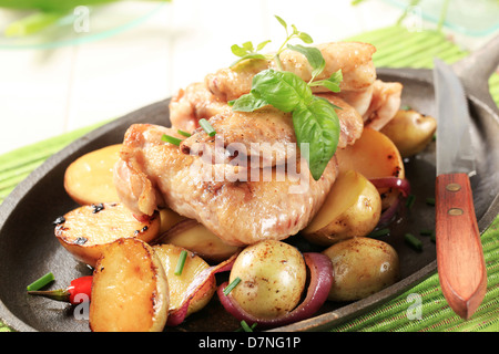 Ailes de poulet et pommes de terre saupoudrée de ciboulette Banque D'Images