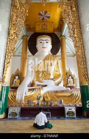 Homme priant à grand Bouddha assis à la pagode Shwedagon à Yangon, Myanmar 1 Banque D'Images