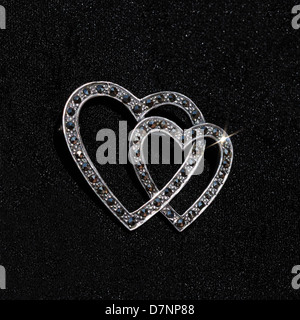 Broche coeur en argent sterling avec des pierres marcassite contre un fond noir. Banque D'Images