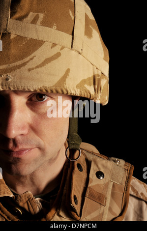 La moitié face portrait d'un soldat britannique portant des uniformes de camouflage de désert. Banque D'Images