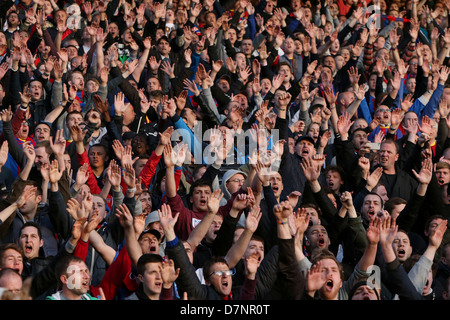 Les fans de football, chantant et scandant dans les stands. Banque D'Images