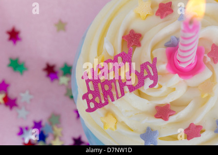Vue à vol d'oiseau un rose cupcake candle lit joyeux anniversaire star cerise sur fond rose Banque D'Images