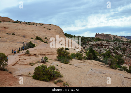 Les Randonneurs marchant sur le long de la Grès Delicate Arch Trail. Arches National Park, Moab, Utah, USA. Banque D'Images