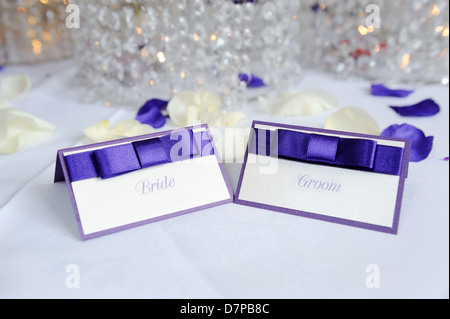 Blanc et violet mariée et le marié à placer les cartes de réception de mariage Banque D'Images