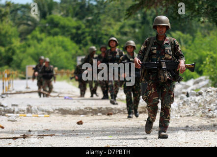 DATU UNSAY, Philippines, le 12 mai, 2013 -- Espagnol soldats patrouillent le long de la route dans le sud de la ville de Datu Unsay philippin à Maguindanao, 12 mai 2013, un jour avant la tenue d'élections de mi-mandat, à l'échelle nationale. L'armée a soulevé l'alerte rouge dans la région comme la Commission des élections ses délégués-les pour fixer le processus politique. Dans le passé, les élections des Philippines ont été gâchées par la violence et la corruption, mais cette année, le gouvernement du Président Benigno Aquino a appliqué plusieurs mesures en vue de prévenir et de lutter contre l'effusion de sang. Banque D'Images