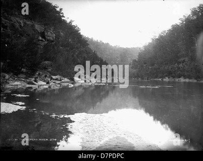 Cette photographie en noir et blanc capture les sources de la rivière Nepean en Australie, prise par le Powerhouse Museum. L'image souligne la beauté naturelle de la rivière, mettant en valeur le paysage accidenté et les eaux calmes de la source de la rivière. Banque D'Images