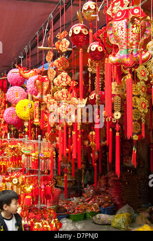 Close up vertical traditionnel de décorations rouge et or en vente dans le vieux quartier en préparation pour le Têt, Nouvel An vietnamien Banque D'Images