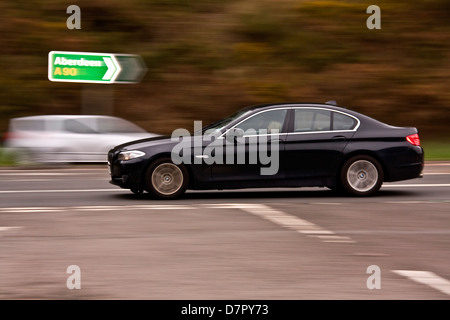 Synchro flash arrière technique utilisée pour capturer une voiture BMW qui se déplacent le long de l'autoroute en direction de Dundee, Royaume-Uni Banque D'Images