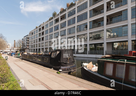 Regents Canal au coeur Londres différentes formes de barge logement appartements waterside contraste avec des bateaux et des bureaux à Sunshine Banque D'Images