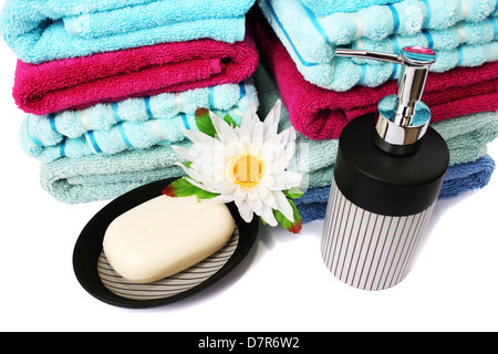 Pile de serviettes, savons et fleurs isolé sur fond blanc. Banque D'Images