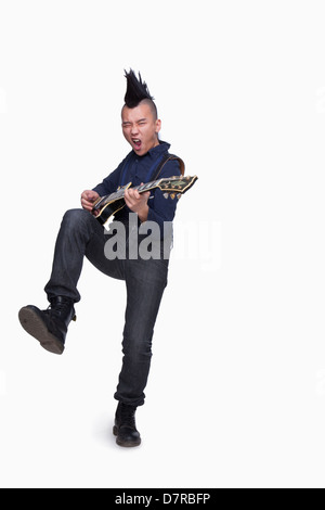 Jeune homme avec punk qui joue de la guitare Mohawk Banque D'Images