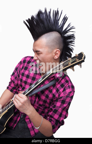 Jeune homme avec punk qui joue de la guitare Mohawk Banque D'Images