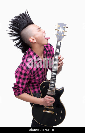 Jeune homme avec punk qui joue de la guitare Mohawk Banque D'Images