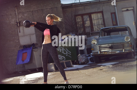 Athlète féminin dans un entraînement Crossfit outdoors Banque D'Images